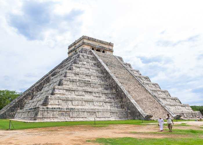 The majestic Kukulkan Pyramid at Chichén Itzá archaeological site under a cloudy sky, one of the New Seven Wonders of the World in Mexico.