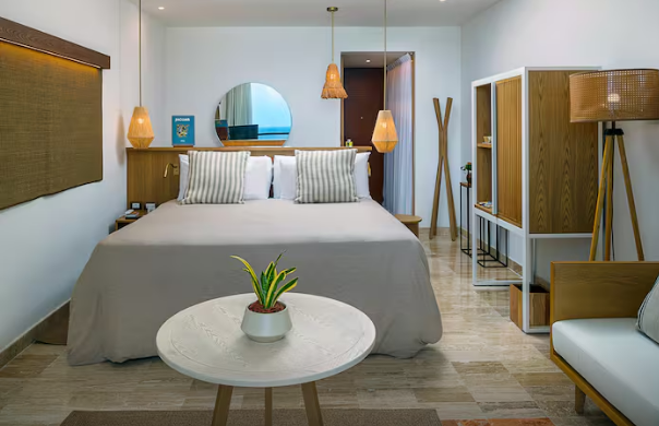 Interior de una habitación de lujo recién remodelada en Paradisus Cancún, con diseño contemporáneo, tonos neutros y detalles en madera.